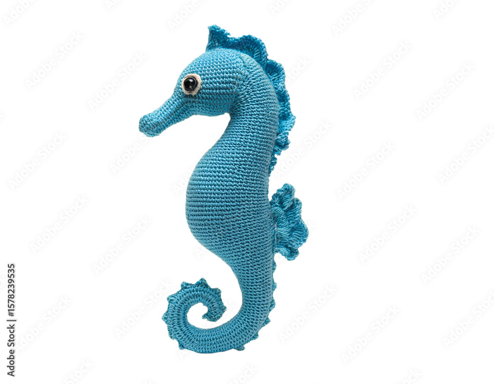 Naklejka premium A charming blue seahorse crochet toy stands out against a stark transparent background, perfect for crafts and children themes.