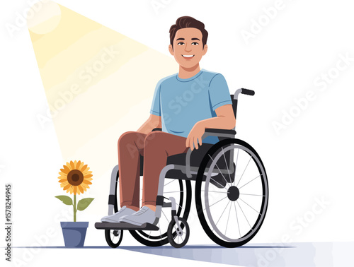 A smiling man in a blue shirt sitting in a wheelchair with a sunflower next to him on white
