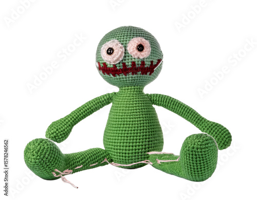 A handmade crochet green monster toy with cute details sits against a transparent background, perfect for crafts and playful designs.