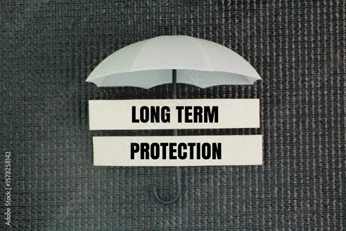 Umbrella and paper with the word long term protection. the sustained effectiveness of a vaccine or natural infection in providing immunity against a disease over an extended period