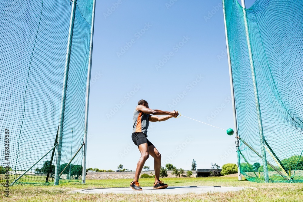 Naklejka premium Man playing hammer throw against sky on sunny day