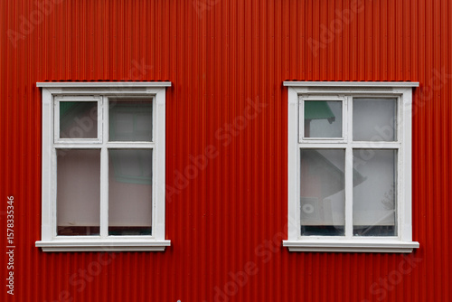 View of white windows on a red house.