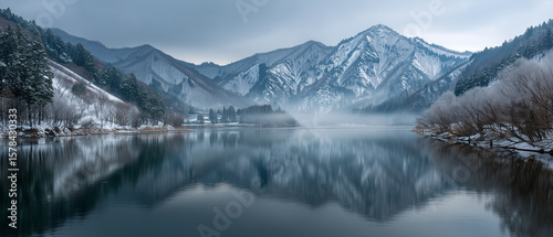 Wallpaper Mural A serene landscape of Lake Hibara with foggy air and snow-covered islets, framed by forested hills and mountain peaks.  Torontodigital.ca