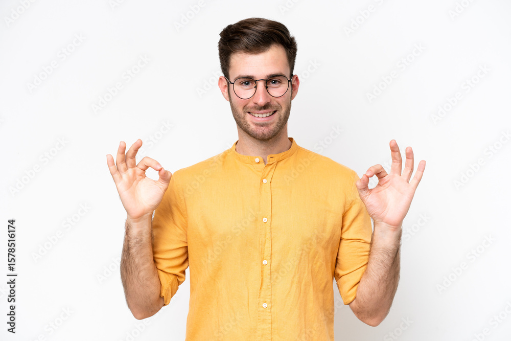 Fototapeta premium Young caucasian man isolated on white background showing ok sign with two hands