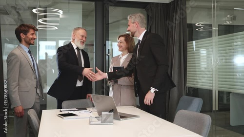 Businessmen shaking hands during a meeting.