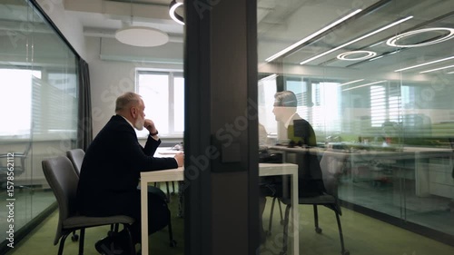 Business office with businesspeople, with blurred bokeh background, view from glass wall.