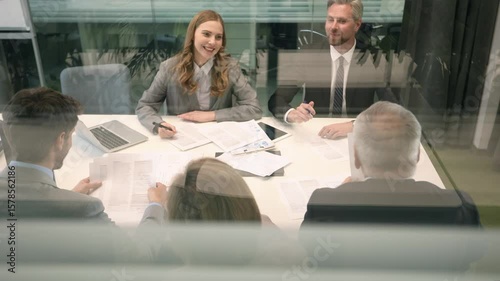 Business office with people casual wear, with blurred bokeh background, view from glass wall