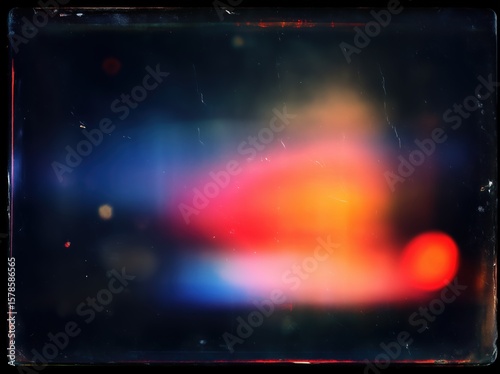 Abstract grunge film grain texture with colorful vintage light leaks on dark background, retro blurry orange blue red streaks for design elements overlay.​