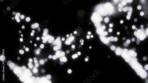 Abstract flowing particles of light swirling against a dark black background