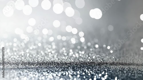 Elegant silver glitter and bokeh background, providing a shimmering and celebratory feel with sparkling blurred circles and reflective surface