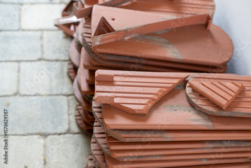 New terracotta roof tiles stacked on the floor