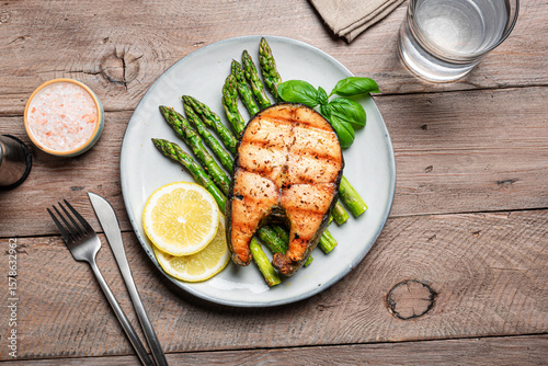 Grilled salmon fish steak over grilled asparagus