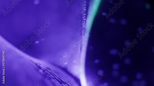 Abstract purple liquid substance with light and bubbles in a dynamic motion