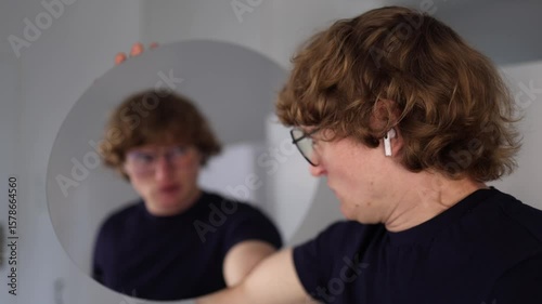 Young man turns toward the mirror and screams in panic as his reflection mirrors his emotion creating a tense and chaotic moment of small hysteria and emotional outburst