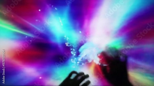 Colorful interactive digital art with hands interacting with abstract light and particles