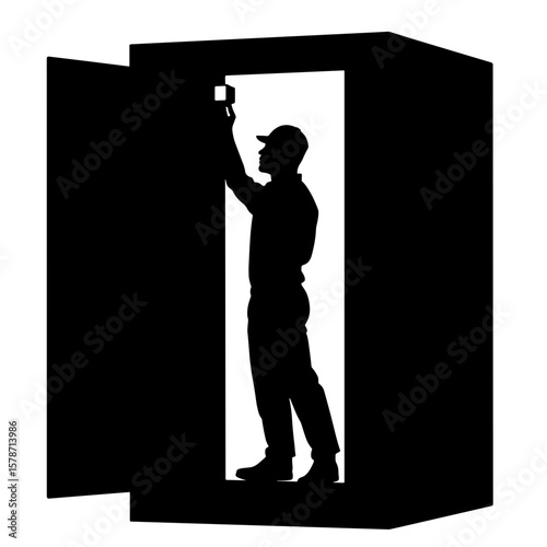 Technician silhouetted adjusting sensor in cold storage, environmental control