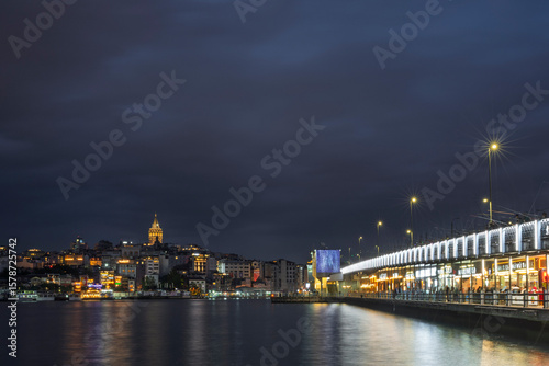 Fototapeta Naklejka Na Ścianę i Meble -  Galata Bridge, at night. ⁦This bridge ⁩⁦spans the Golden Horn, connecting the old city with Beyoglu⁩⁦, the northern district of Istanbul.⁩ The city lights are reflected in the Bosphorus