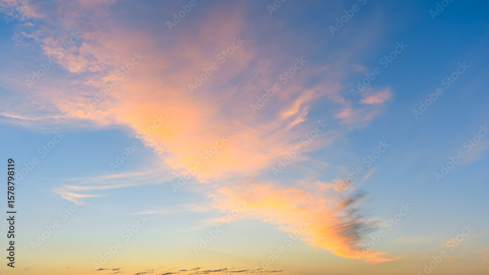 Light pink clouds float near the horizon under a clear blue morning sky during early sunrise. Light pink clouds float near the horizon under a clear blue morning sky during early sunrise.