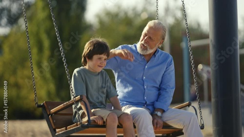A heartwarming interaction between a loving grandparent and grandchild enjoying playful moments swinging in the park