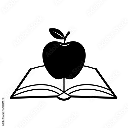 An apple sits atop an open book isolated on white background
