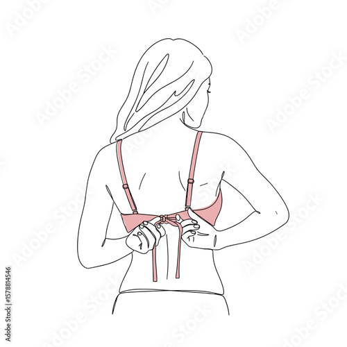 Woman tying her pink bra while preparing for wearing it on Bra Day  