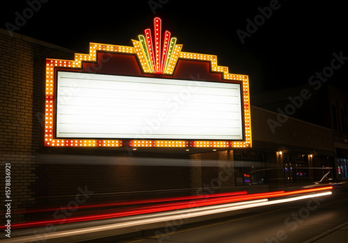 Retro marquee sign with lights, featuring a large blank space for custom messages, framed by a red and gold border, set against a dark brick wall at night.