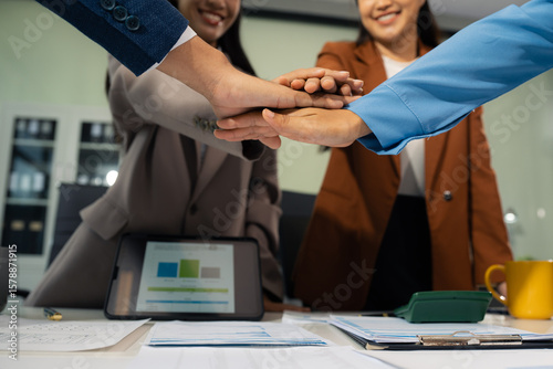 business people holding each others wrists, join hands together, support and unity, team strength and power, colleagues involved in team building activity.