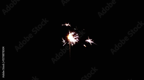 Stunning visual effects of sparklers lighting up in the dark symbolize celebration and endless joy that is mesmerizing. Smoke envelops the sparks in the darkness. Slow motion. Close up.