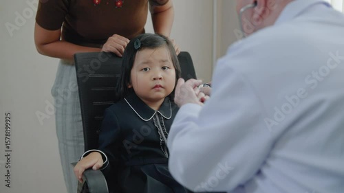 Doctor examines child patient's condition in hospital, health care concept