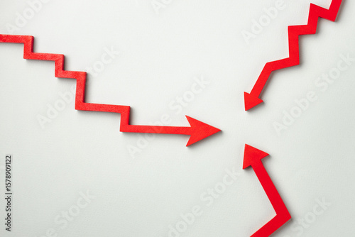 Fotografie Three red zigzag arrows on a light gray background that converge at the center