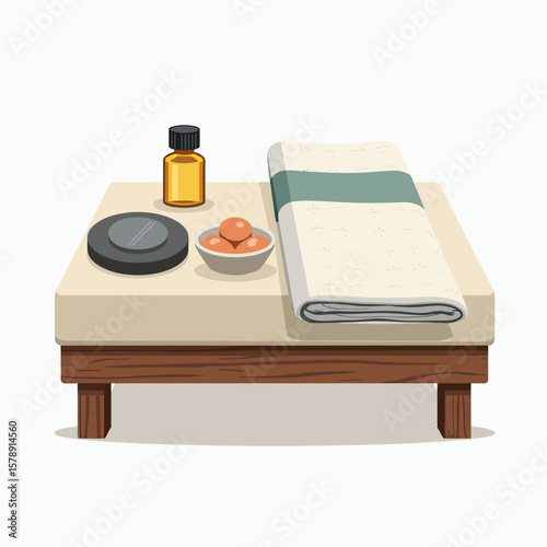A fully prepared massage table featuring a bottle of essential oil, hot stones, and a bowl, ideal for a relaxing and rejuvenating spa experience, promoting a sense of well-being.
