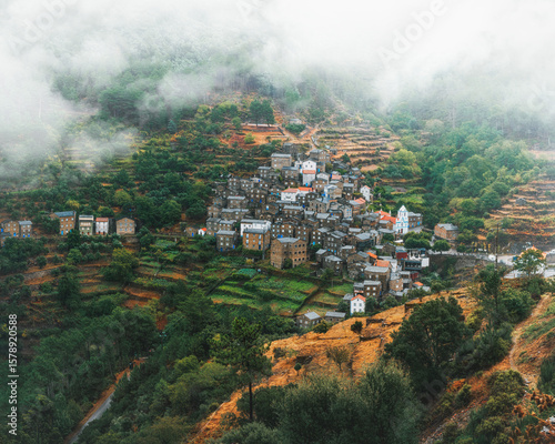 A tiny town among cascades of fields in the middle of a foggy day (Piódão - Portugal)