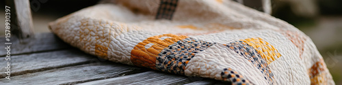 Cream, Gold, and Navy Blue Patchwork Quilt on Wooden Surface