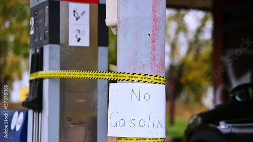 Empty Gas Station Pump with No Gasoline Sign and Warning Tape in Suburban Setting