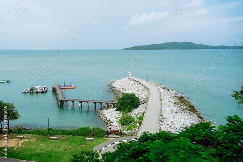 Small lighthouse on the shore of the sea at Khao Laem Ya, Rayong, Thailand. Little wooden white life guard tower. Summer travel vacation and holiday concept. Seascape Bridge and Pier.