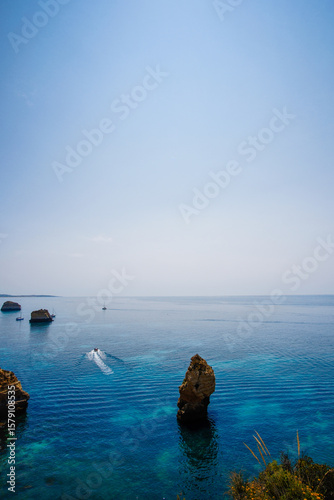 Rocks rise from crystal waters off Algarve coast in Portugal