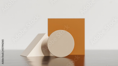 A minimalist geometric still life photograph featuring three solid-colored shapes on a reflective gray surface against a white background .