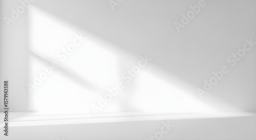 Sunlight streams into an empty white room, casting a bright, geometric light pattern on the walls and floor.