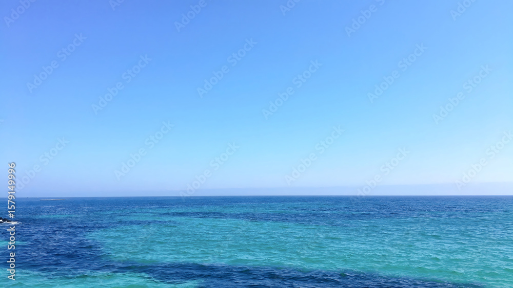 Obraz premium Clear Blue Sea and Sky with Rocky Coastline