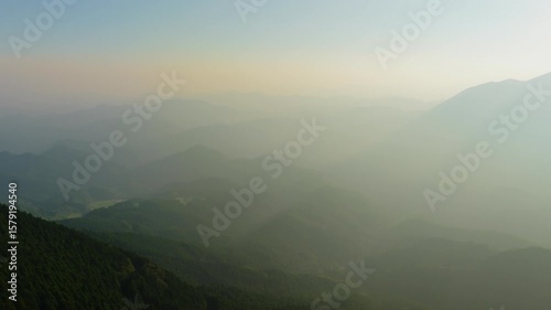 Bad air quality due to haze and smog over mountain landscape at sunset - Aerial view