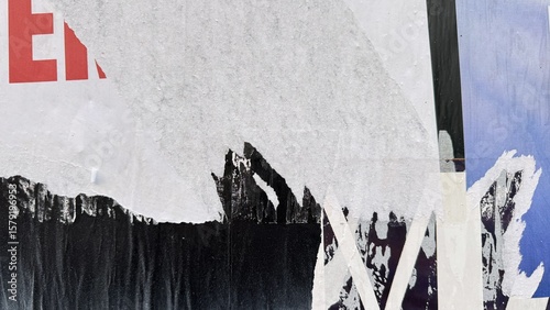 Ripped street posters creating abstract urban artwork with red e letter