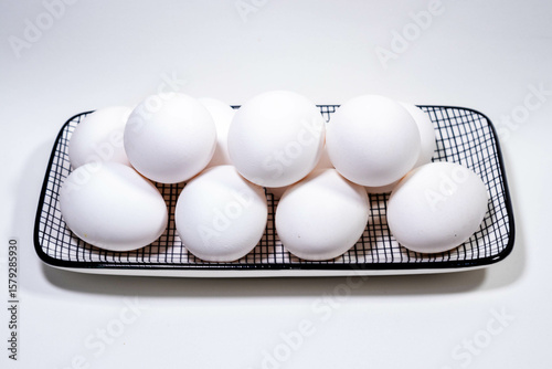 Ovos brancos organizados na bandeja, prontos para o preparo das mais diversas receitas.