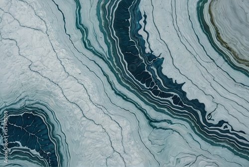 Extreme macro photograph of the surface of a piece of blue cheese, with blue-green veins forming an abstract satellite image of river deltas winding through a white canyon landscape.