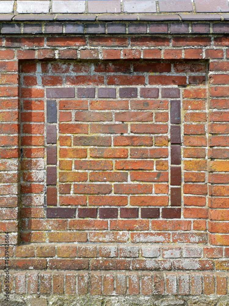 Fototapeta premium Brick wall with recessed panel and dark decorative brick frame. Architectural detail. Structured background. Copyspace.