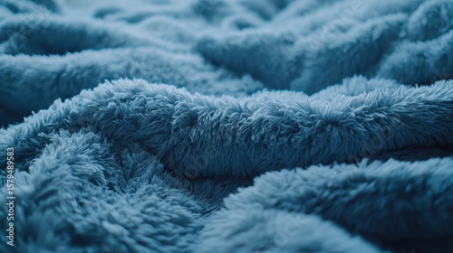 Soft blue blanket draped on a cozy bed creating a warm atmosphere in a relaxing space