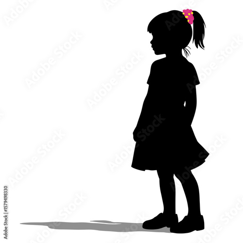 Silhouette of girl standing and looking to side in dress with bow  