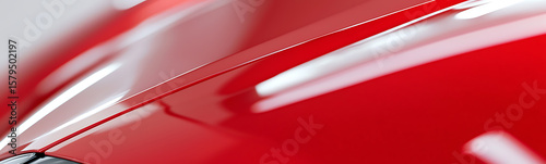Glossy Red Vehicle: Close-up of sleek, vibrant red car paint. The sleek car surface reflects light with high gloss, showcasing design and aerodynamics.
