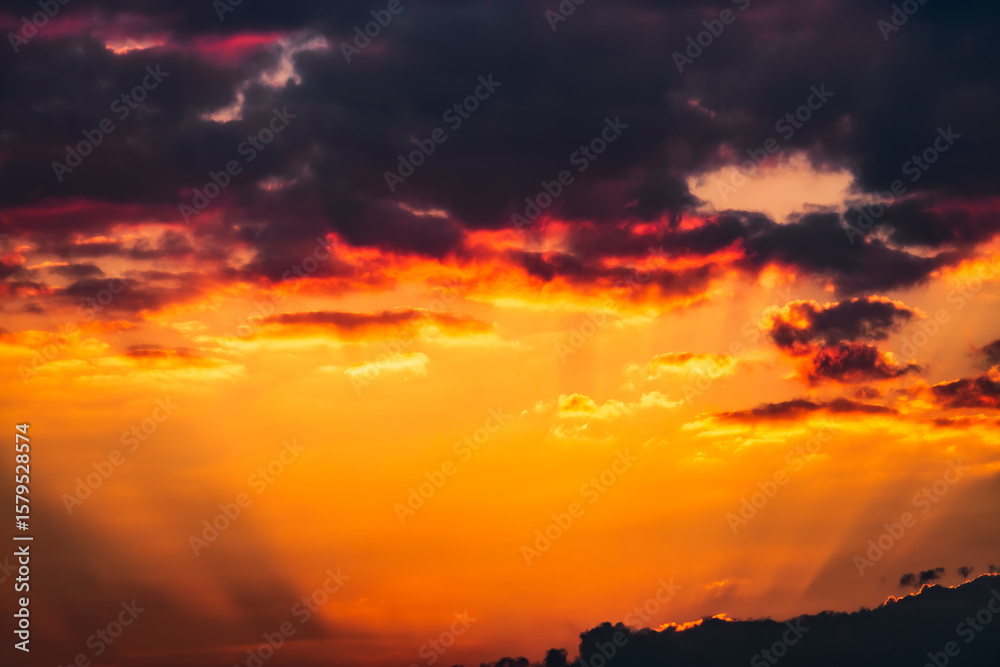 Obraz premium Atardecer dramático con nubes de diferentes formas y colores.