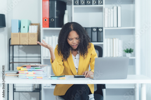 Stress in the office: a professional woman is overwhelmed with her workload at desk in the office