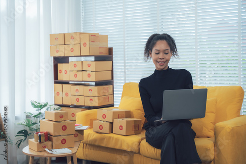 Online Retailer: An online retailer, deeply engrossed in her work, is skillfully managing orders on her laptop. Boxes of packages, ready for shipment, are elegantly stacked around her.